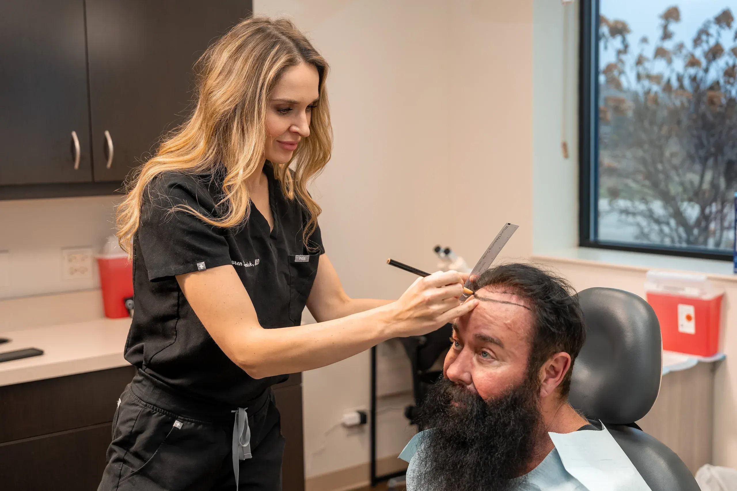 Man examining his hairline in a mirror, considering male pattern baldness treatment options